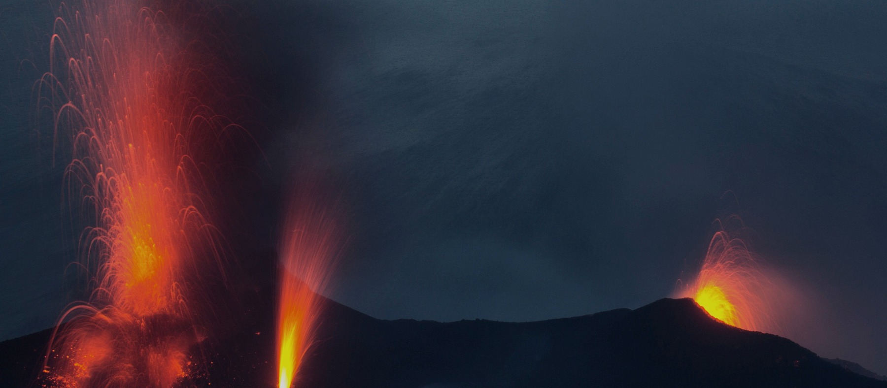 Night-time eruption at Stromboli seen across the Tyrrhenian Sea with glowing ejecta above the summit